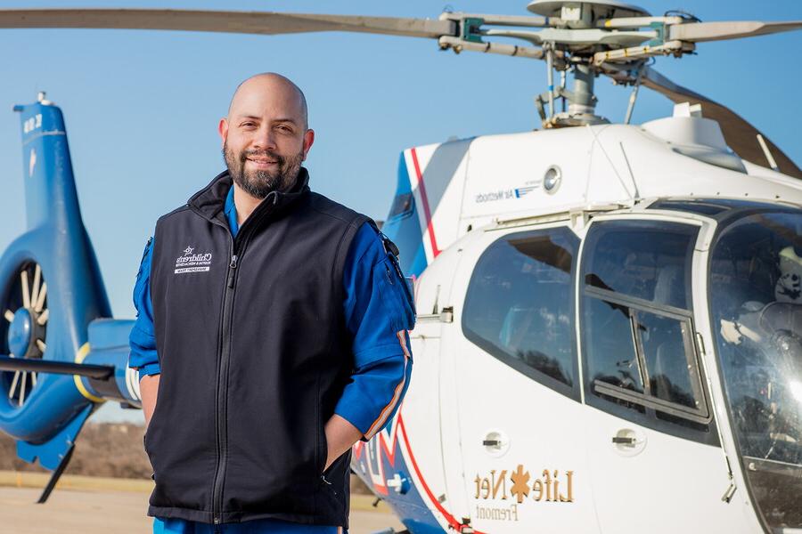 Philip Armendariz, transport nurse, in front of a rescue helicopter
